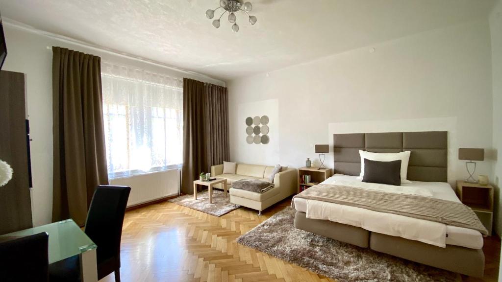 um quarto com uma cama e uma sala de estar com um sofá em Apartment im Grünen em Leoben