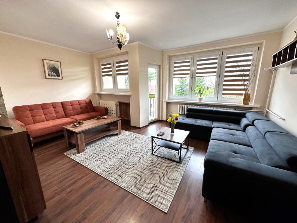 a living room with a couch and a table at Apartament Dąbrowskiego - Gliwice in Gliwice