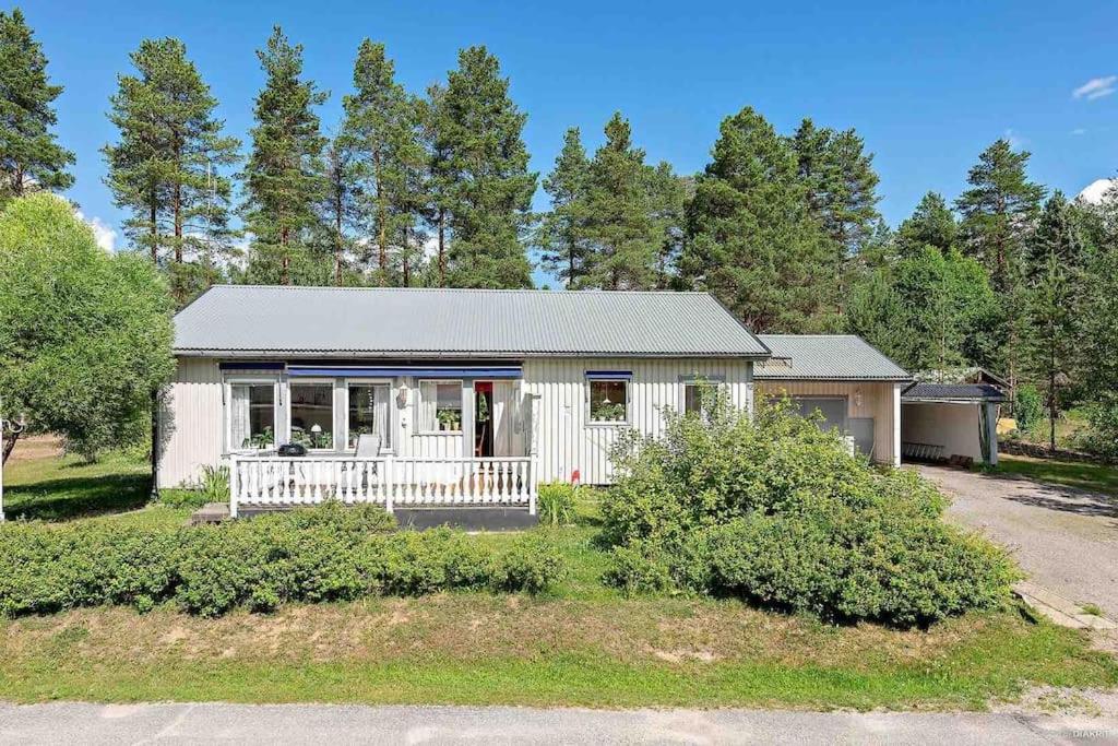 Granträsket的住宿－Family house in Swedish Lapland，白色的小房子,设有门廊