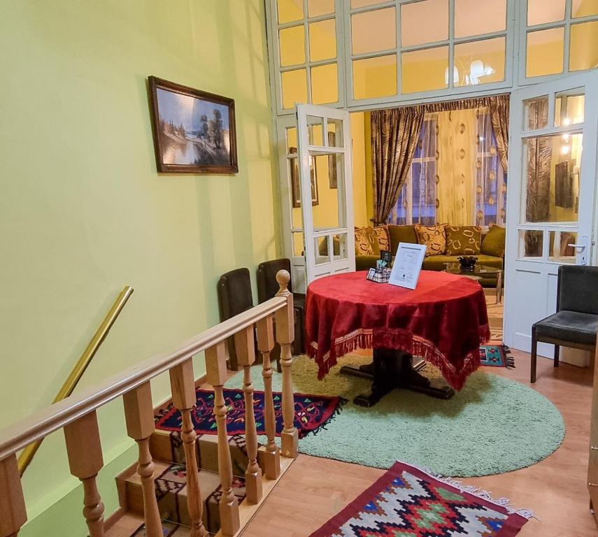 sala de estar con mesa y mantel rojo en Liora's Place, en Korçë