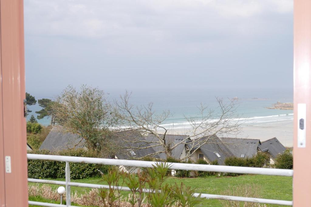 a view of the beach from the balcony of a house at Kerbugalic Grand gîte, Magnifique vue mer in Trévou-Tréguignec