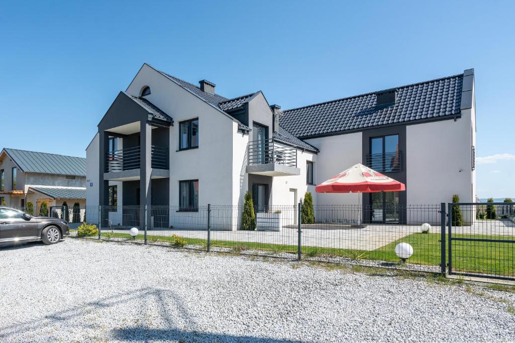 dom z samochodem zaparkowanym przed nim w obiekcie PIONOW Pokoje Hotelowe - adults only w mieście Krynica Morska