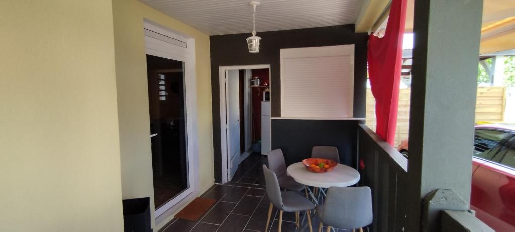 a small kitchen with a small table and chairs at LASYMPHO - Séjour de repos à la campagne in Le François