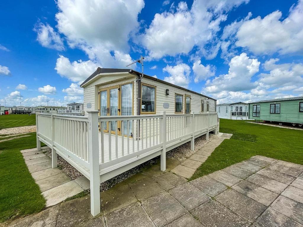 a large white house with a porch at Lovely Caravan With Decking At Millfields Caravan Park Ref 87025f in Skegness