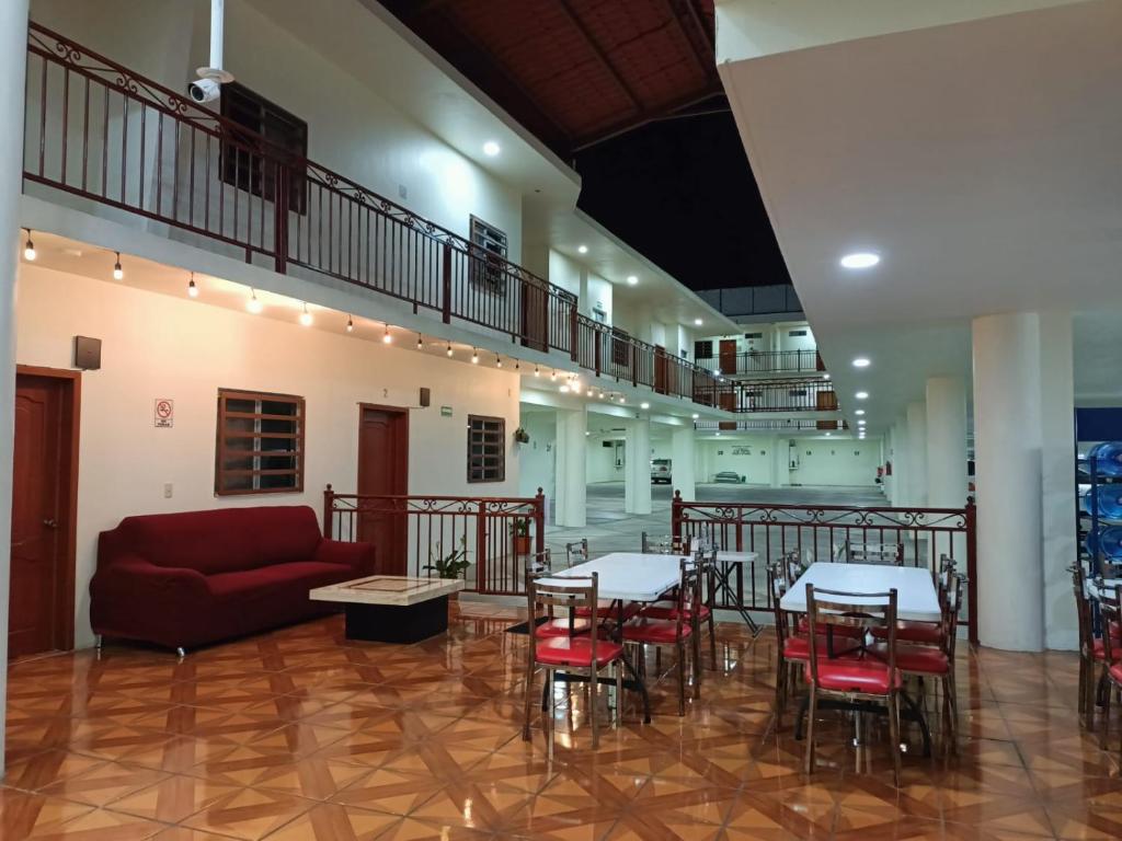 a living room with a couch and tables and chairs at Hotel John & Rose in Comitán de Domínguez