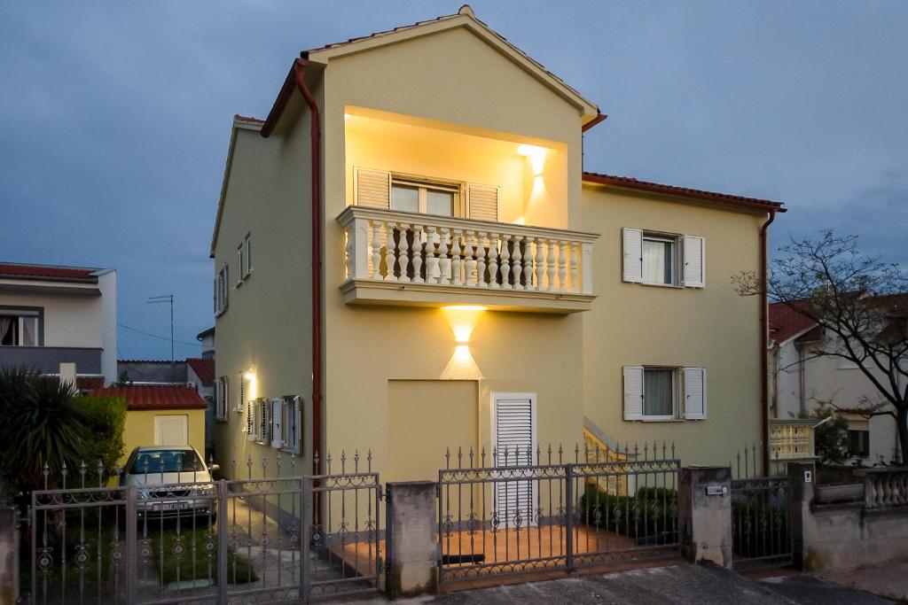 a house with a balcony on top of it at Apartments4You in Vodice