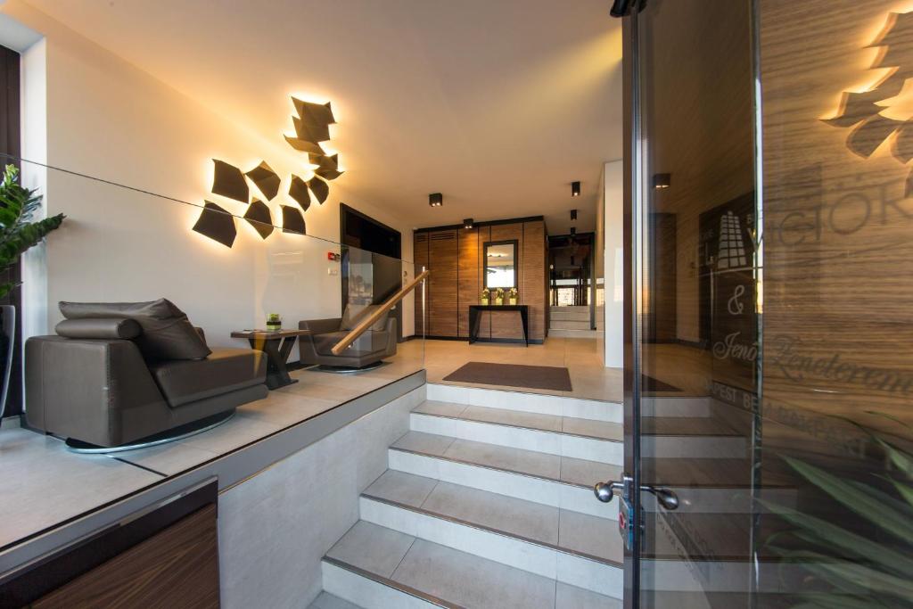 a lobby of a house with a staircase with chairs at Boutique Hotel Victoria Budapest in Budapest
