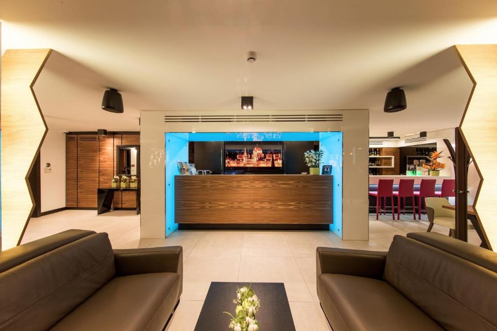 a living room with two couches and a bar at Boutique Hotel Victoria Budapest in Budapest