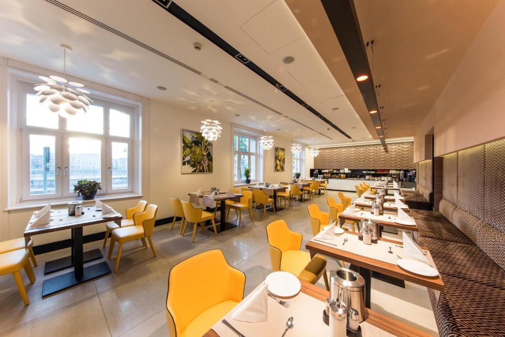 a dining room with tables and yellow chairs at Boutique Hotel Victoria Budapest in Budapest