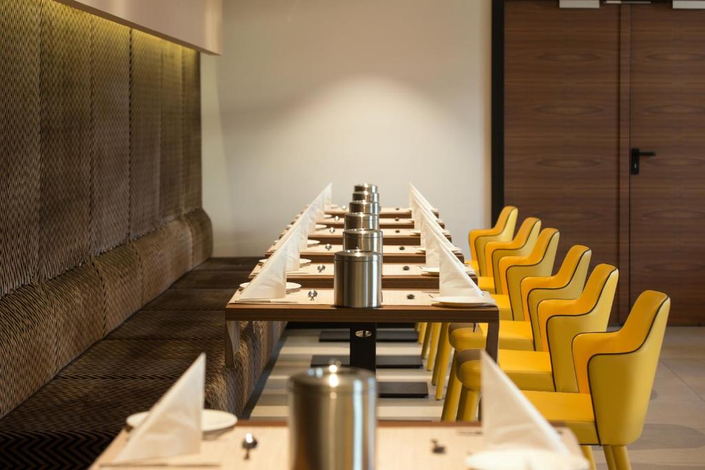 a long table in a room with yellow chairs at Boutique Hotel Victoria Budapest in Budapest