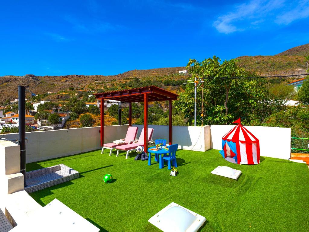 a backyard with a playground and a gazebo at FAMILY COTTAGE AMONG OLIVE TREES in Agüimes