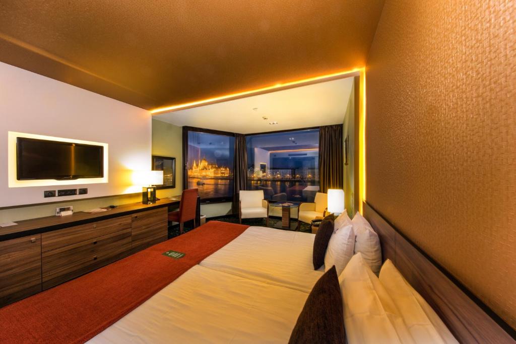 a hotel room with a large bed and a television at Boutique Hotel Victoria Budapest in Budapest
