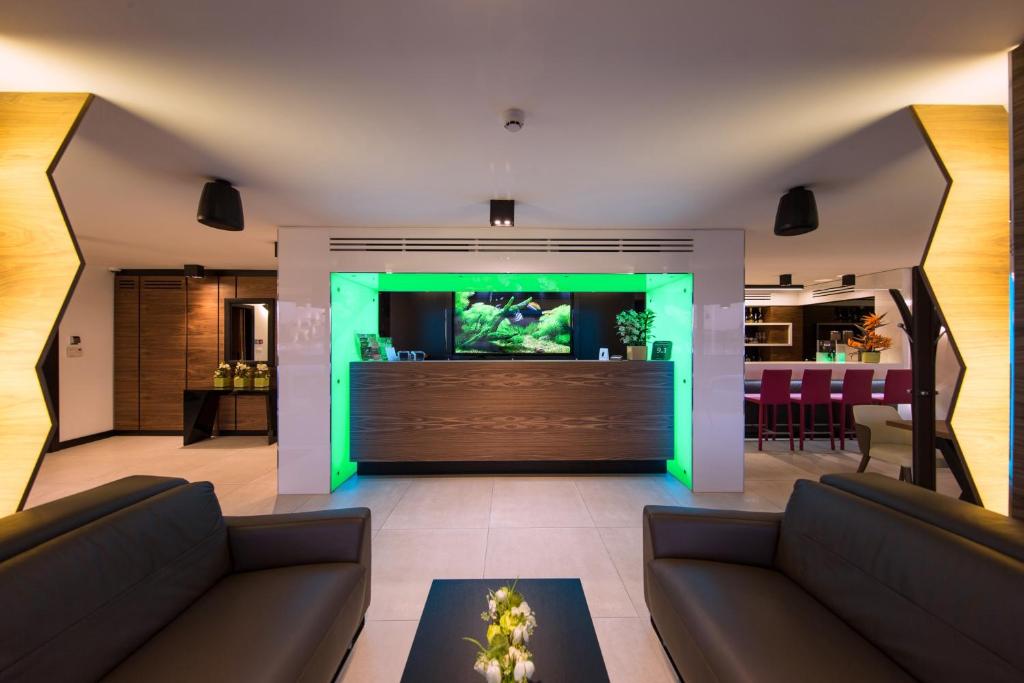 a living room with two couches and a fish aquarium at Boutique Hotel Victoria Budapest in Budapest