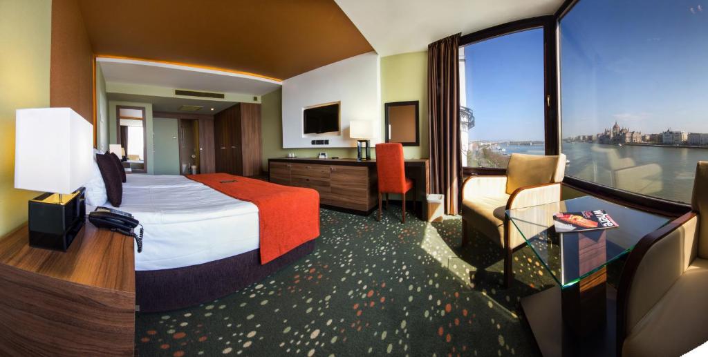 a hotel room with a bed and a large window at Boutique Hotel Victoria Budapest in Budapest