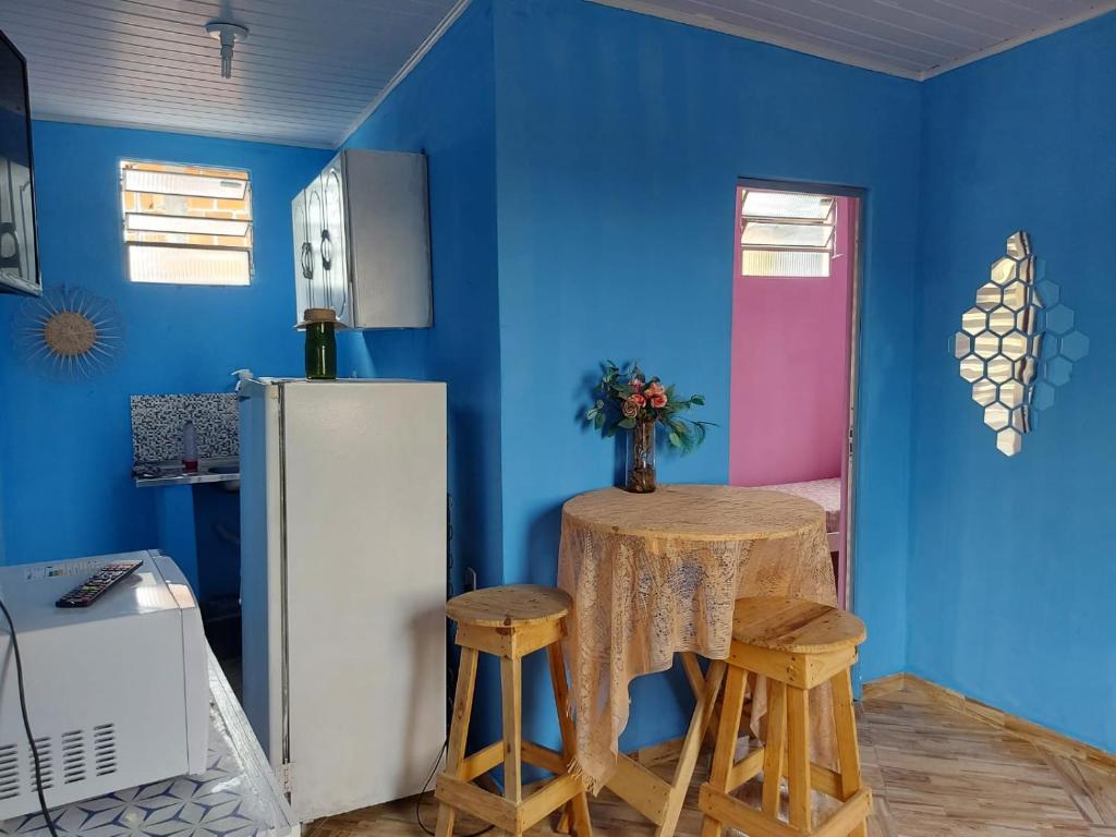 a kitchen with blue walls and a white refrigerator at Casa inteira com AR 2/4 in Salvador