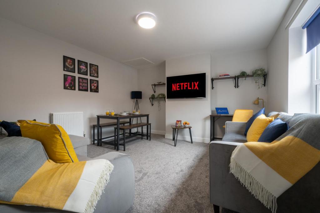 ein Wohnzimmer mit 2 Sofas und einem TV in der Unterkunft 3 bedroom Cannock flat ideal for groups in Great Wyrley