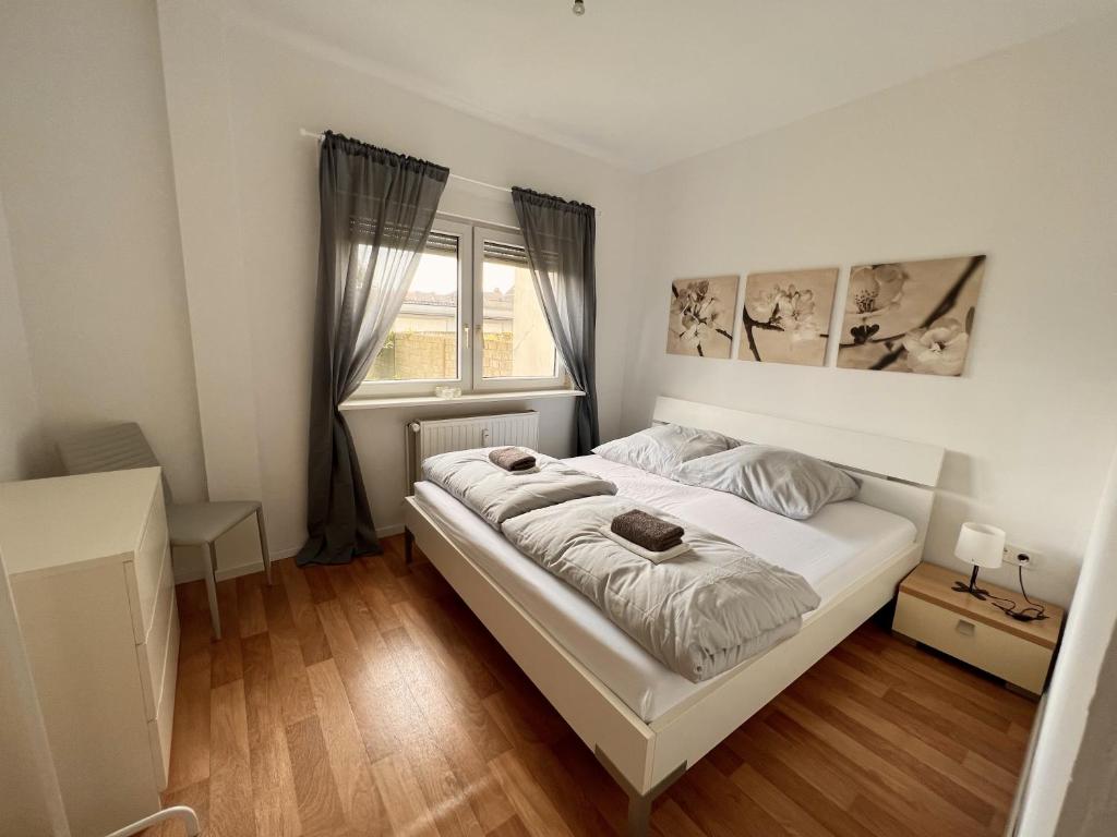 una camera con un letto bianco e una finestra di Apartment zentral in Duisburg 25 Min Messe Düsseldorf und Essen a Duisburg