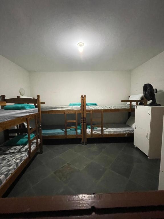 ガラパリにあるHope Hostel Guarapariの二段ベッド2台、冷蔵庫が備わる客室です。