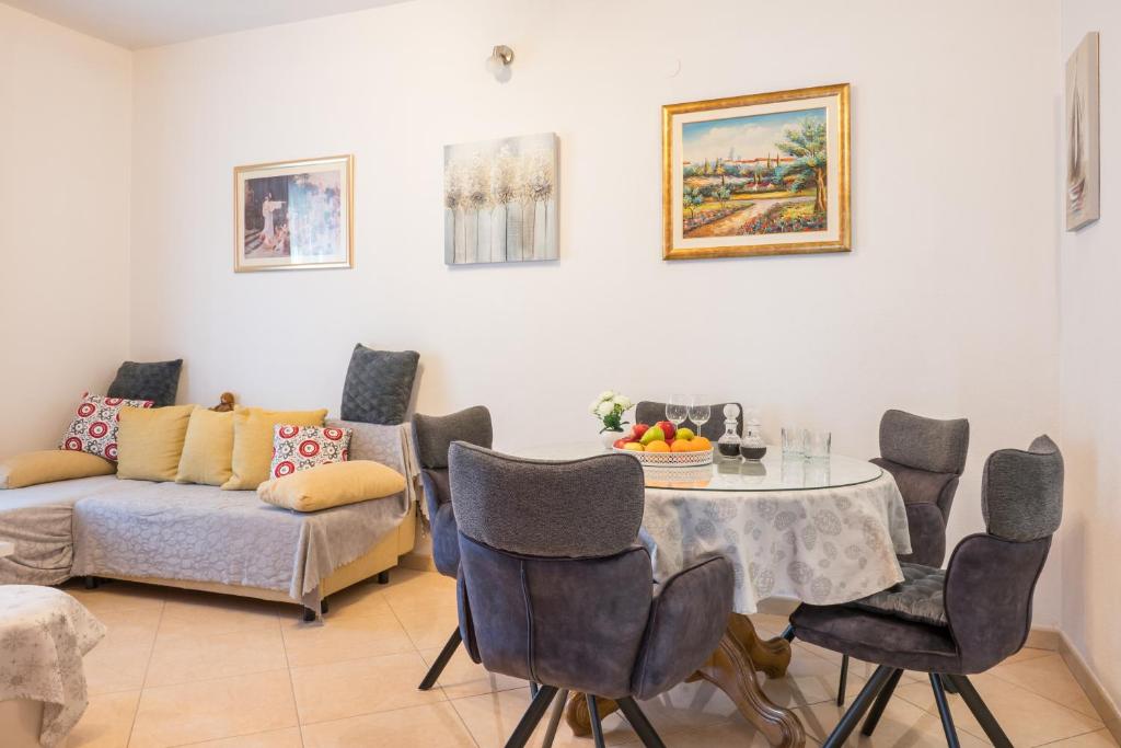 a living room with a table and chairs and a couch at Four Hills Apartment in Žrnovnica