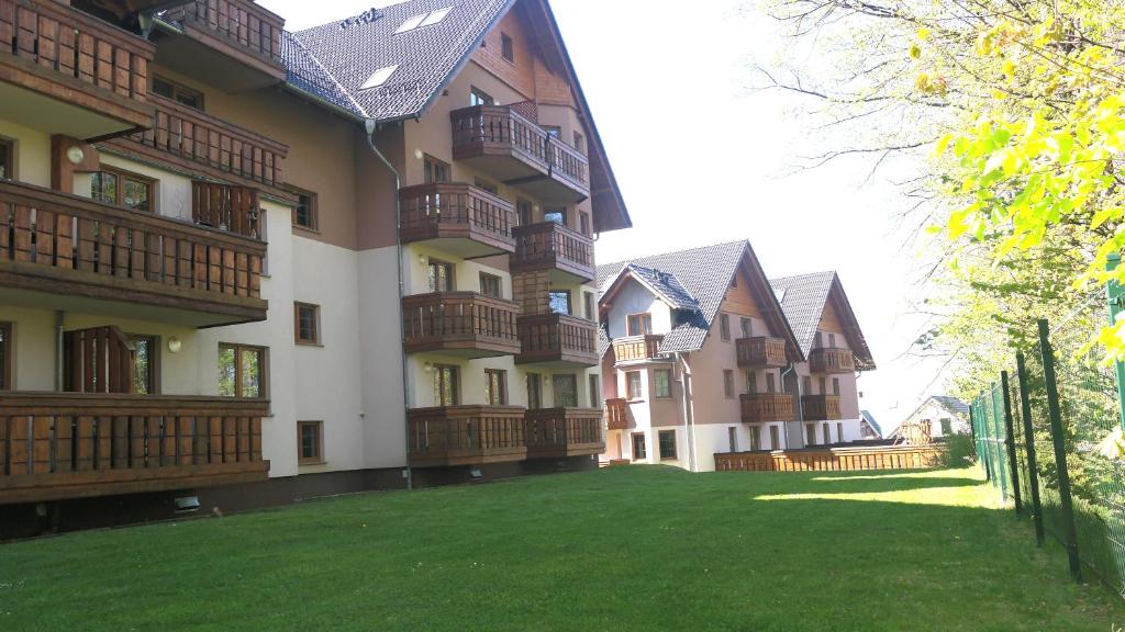 duży budynek z balkonem i zielonym dziedzińcem w obiekcie Apartament Miedzy Strumykami Karpacz w mieście Karpacz
