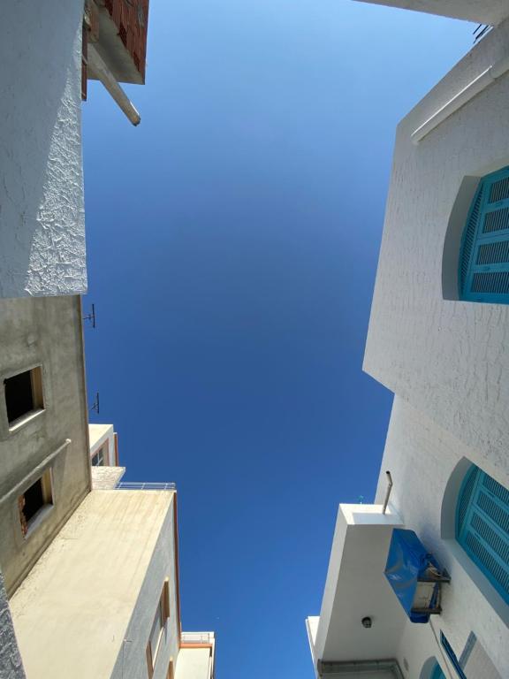a view of the blue sky from between two buildings at Maison la perle de Hammam Sousse in Hammam Sousse