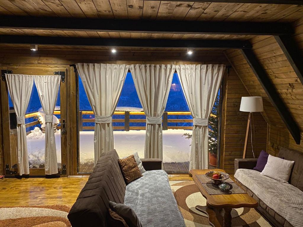 a living room with a couch and a large window at Vikendica Aview in Štrpce