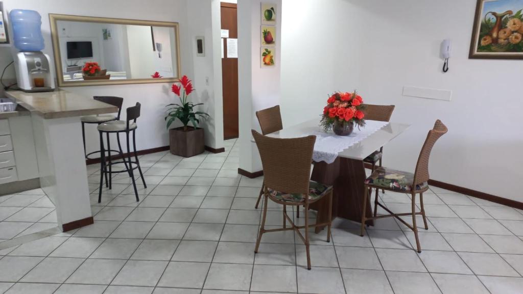 ボンビーニャスにあるApto. 2 quartos em Bombinhas (60 m da praia)のキッチン(カウンター、テーブル、椅子付)
