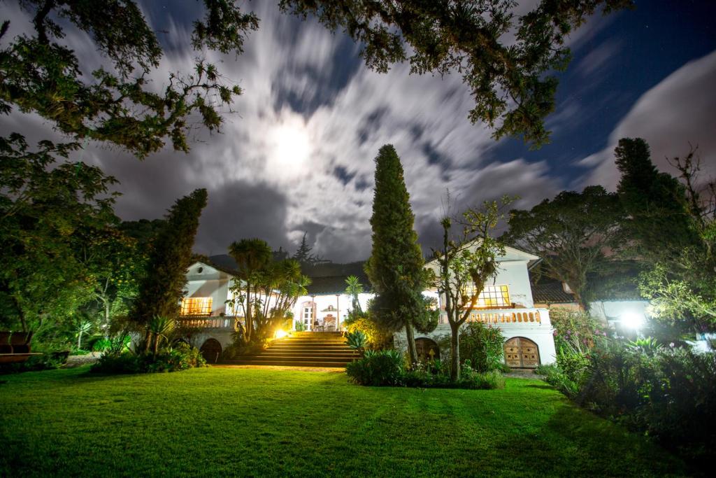 an exterior view of a house at night at Hacienda Cusin in Otavalo