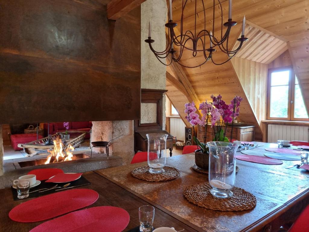 a dining room with a table and a fireplace at La Vallombreuse in Menthon-Saint-Bernard