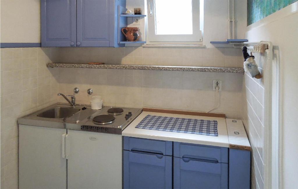 a small kitchen with a stove and a sink at Stunning Apartment In Martinscica With Kitchen in Martinšćica