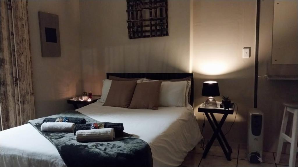 a bedroom with a large bed and a chair at Log in At 118 Self Catering Unit 2 in Meyerton