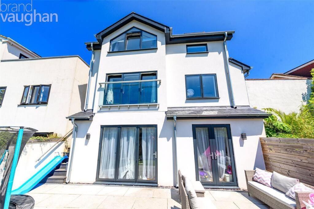 uma casa branca com janelas pretas e um sofá em Stunning & Fun 4 bed home in the heart of Brighton em Brighton & Hove