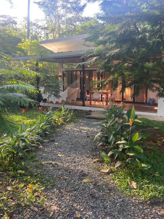 a house with a porch and a patio at Caribbean Irie - charming, luxurious bungalow in nature with AC & fiber optic wifi in Puerto Viejo