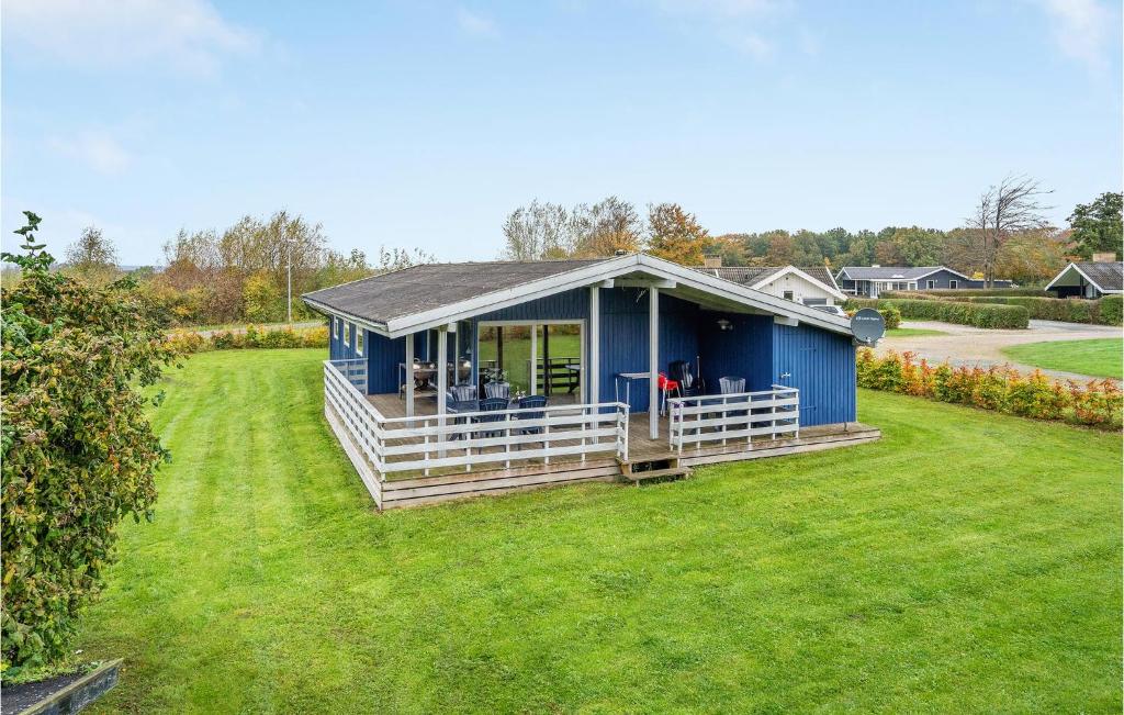 a blue house on a yard with a grass field at Holiday Home Egernsund With A Fireplace 320 in Egernsund