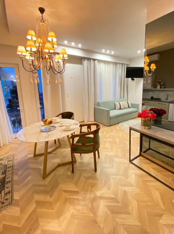 a living room with a table and chairs and a couch at Atelie home experience serres in Serres