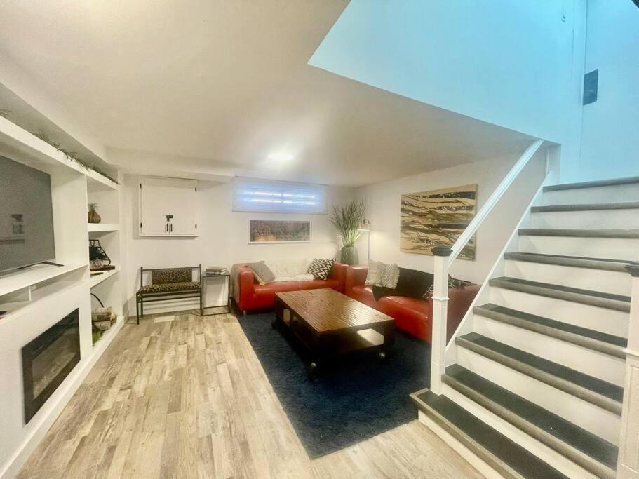 uma sala de estar com um sofá, uma mesa e escadas em Urban KW Gem - Private 2 Bedroom Apartment ! em Kitchener
