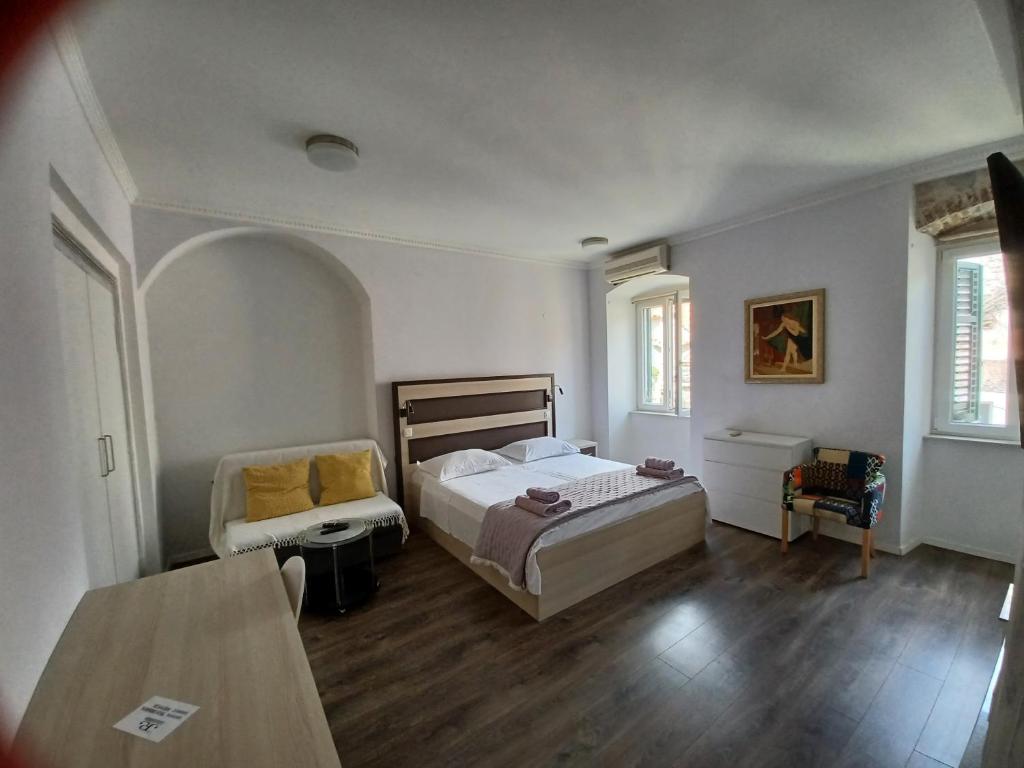 a bedroom with a bed and a chair and a table at JR Luxury Guesthouse in Split