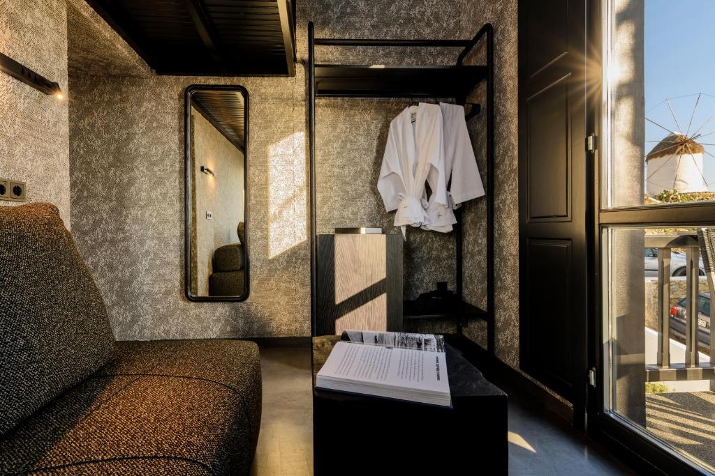 ein Wohnzimmer mit einem Sofa und einem Spiegel in der Unterkunft She Mykonos Boutique Hotel in Mykonos Stadt