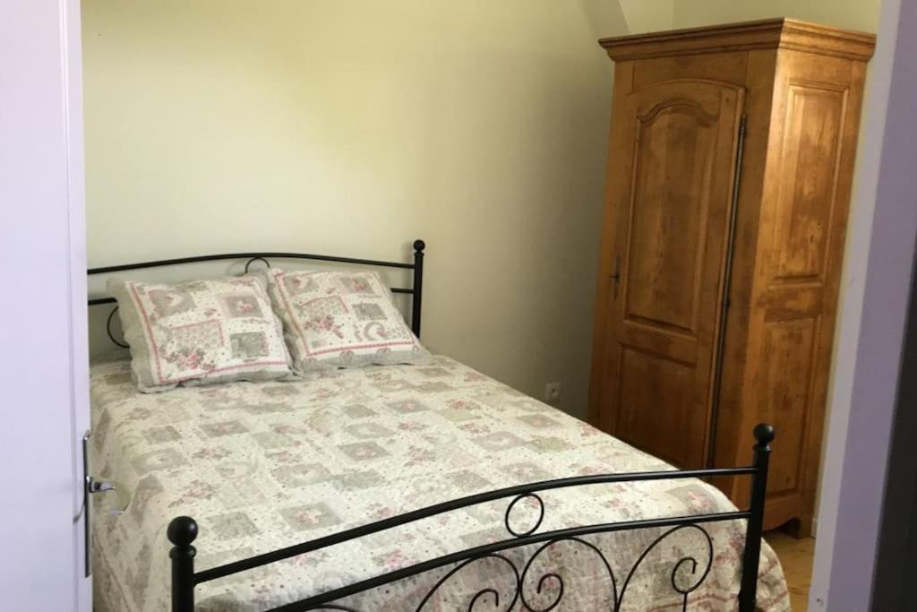 - une chambre avec un lit et une armoire en bois dans l'établissement Maison individuelle, 