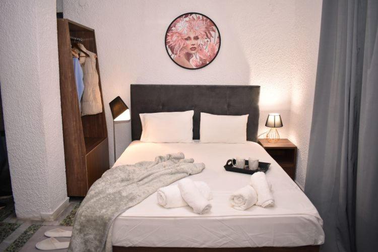 1 dormitorio con 1 cama con toallas en PELEKAN rooms and apartments ATHINA 23, en Pefkohori