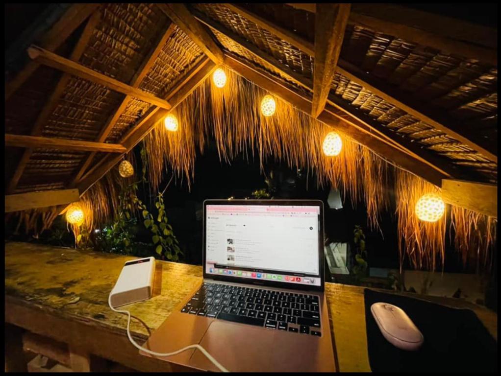 a laptop computer sitting on a table with a mouse at Siargao Zita's Garden Inn in General Luna