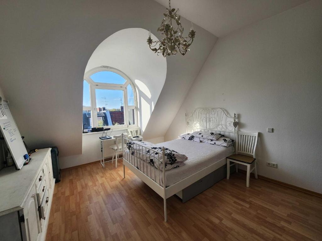 um quarto com uma cama branca e uma janela arqueada em One Private room available in a two room apartment in Tegel, Berlin em Berlim