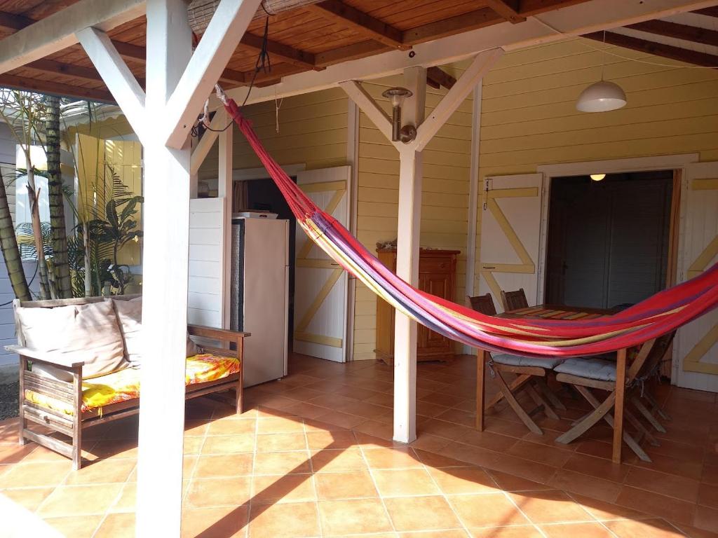 a hammock on a porch of a house at L'ESCALE TROPICALE in Bouillante