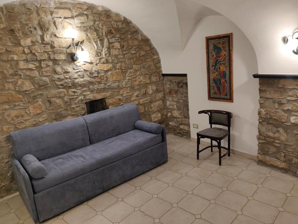 ein Wohnzimmer mit einem Sofa und einer Steinmauer in der Unterkunft Casa Il Carruggio in San Bartolomeo al Mare