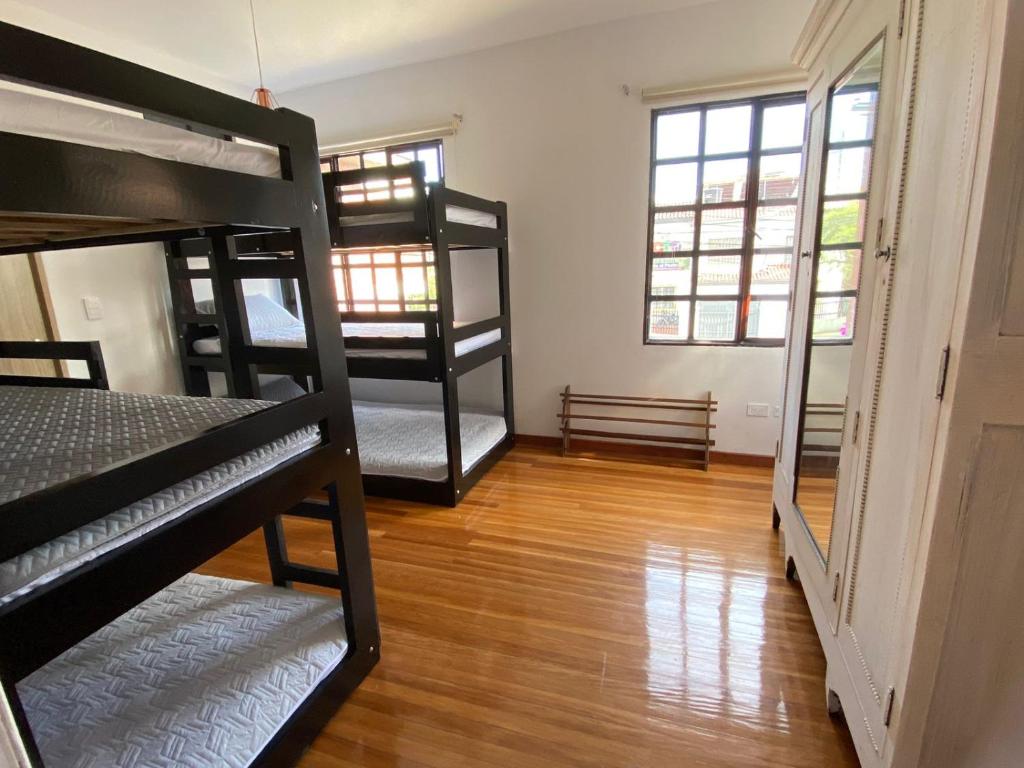 a room with four bunk beds and a hard wood floor at Casa Maria in Bogotá
