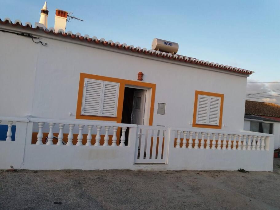 een wit huis met een hek en een deur bij Sunny Aljezur da Viana, (Aljezur, Costa Vicentina) in Aljezur