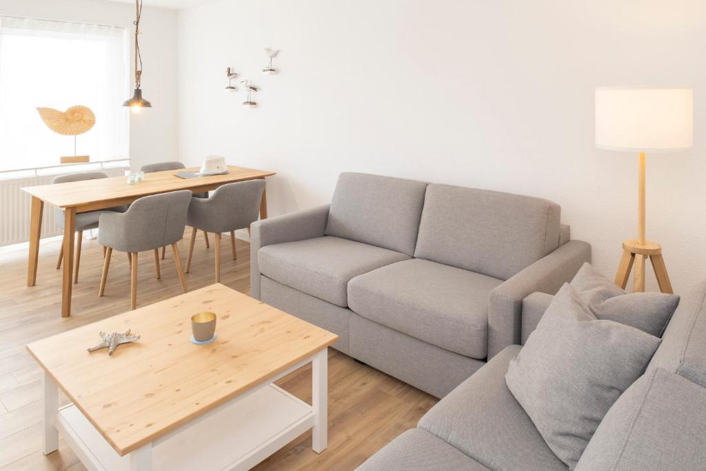 ein Wohnzimmer mit einem Sofa und einem Tisch in der Unterkunft 'Dörpnüst' in Langeoog