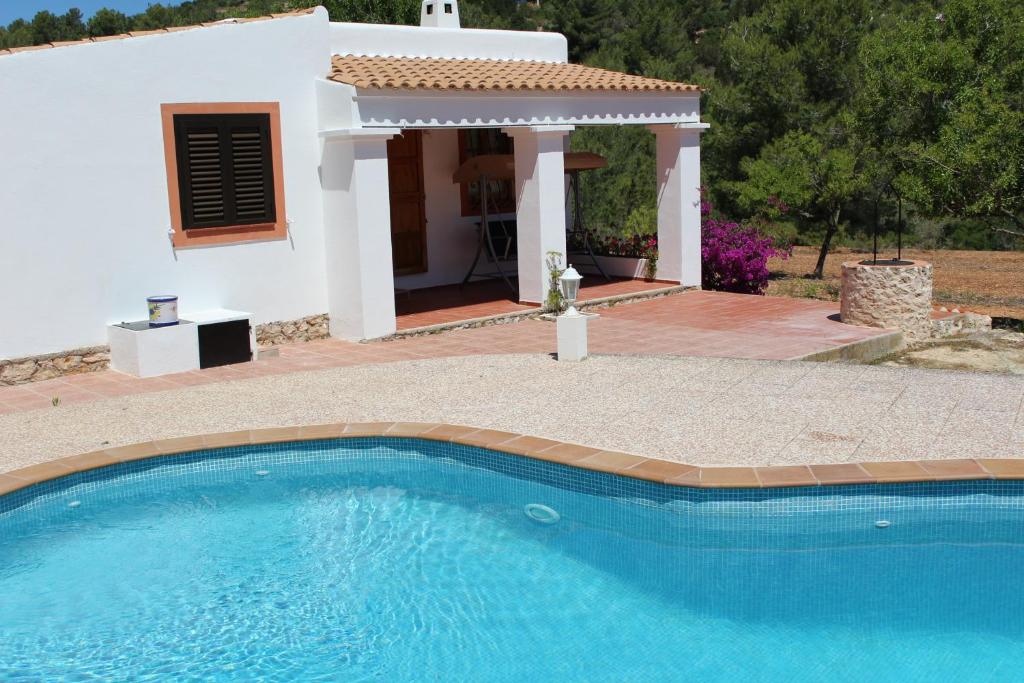 a villa with a swimming pool in front of a house at VILLA GREAT PARADISE in Sant Josep de sa Talaia