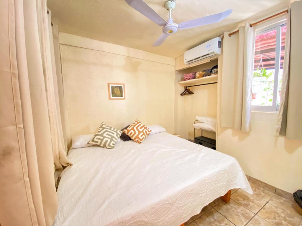 Casa ALOA Ixtapa في اكستابا: غرفة نوم مع سرير ومروحة سقف