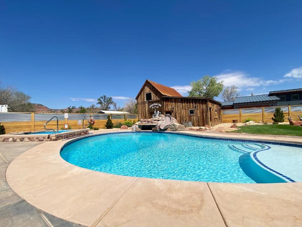 a large swimming pool in a yard with a barn at Timber & Tin D 2Bed 2Bath w Pool & Rooftop Deck in Kanab
